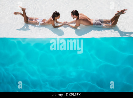 Couple relaxing together in swimming pool Banque D'Images