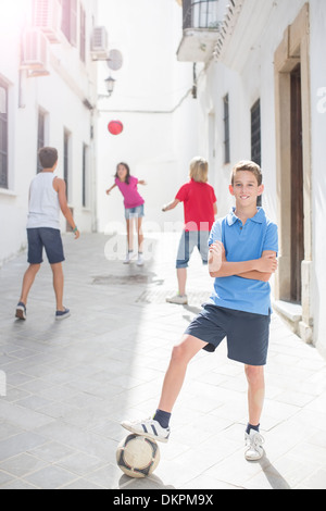 Boy holding soccer ball in alley Banque D'Images