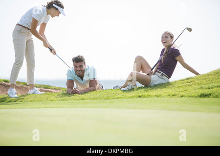 Amis jouant sur terrain de golf Banque D'Images