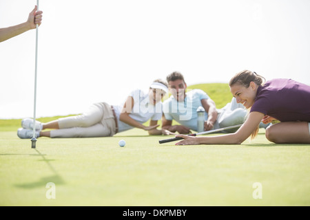 Pose d'amis on golf course Banque D'Images