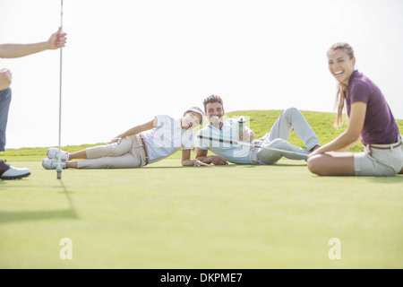 Pose d'amis on golf course Banque D'Images