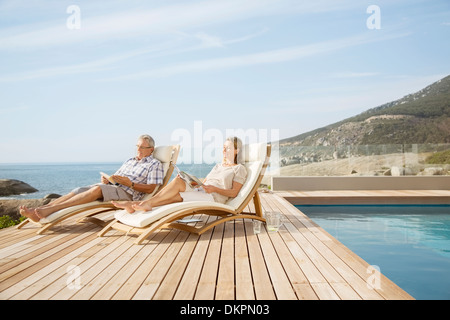 Vieux couple relaxing by pool Banque D'Images