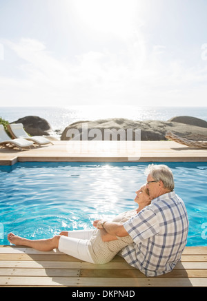 Vieux couple relaxing by pool Banque D'Images