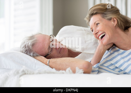 Vieux couple relaxing on bed Banque D'Images