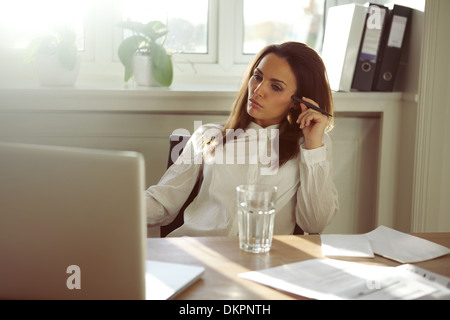 Young businesswoman looking at laptop et la pensée. Belle jeune femme travaillant à la maison. Les femmes de race blanche en home office. Banque D'Images