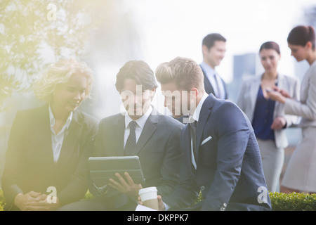 Business people using digital tablet outdoors Banque D'Images