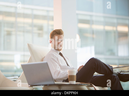 Businessman using laptop in office Banque D'Images