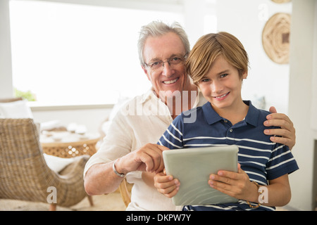 Vieil homme et son petit-fils using digital tablet Banque D'Images