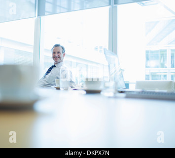 Businessman smiling in conference room Banque D'Images