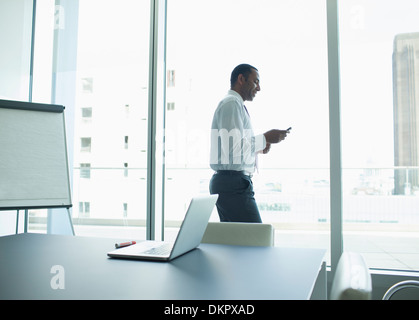 Businessman using cell phone in office Banque D'Images