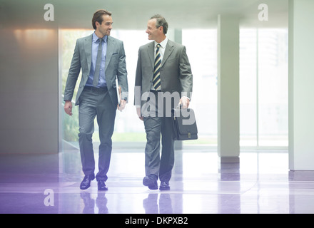 Businessmen talking in office lobby Banque D'Images