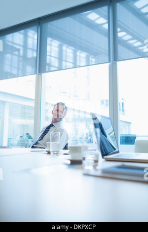 Businessman smiling in conference room Banque D'Images