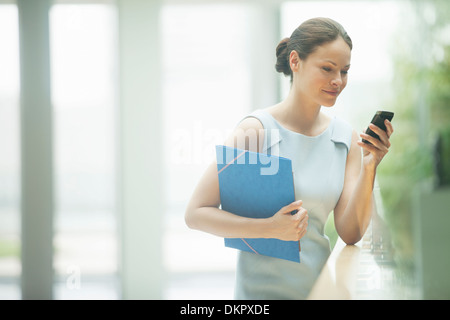 Businesswoman using cell phone Banque D'Images