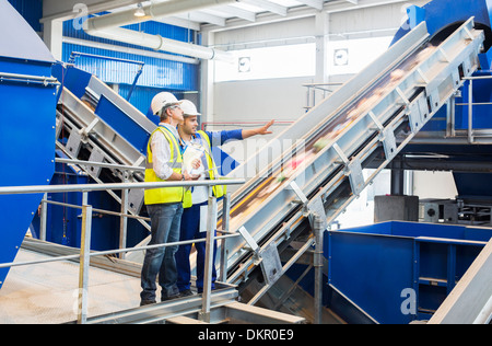 Workers talking in recycling center Banque D'Images