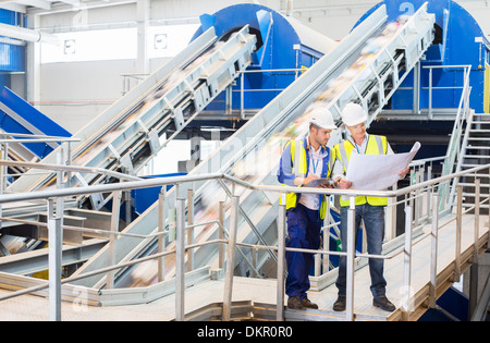 La lecture de bleus travailleurs in recycling center Banque D'Images