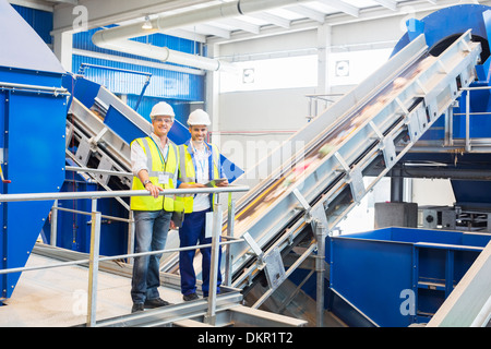 Workers smiling in recycling center Banque D'Images