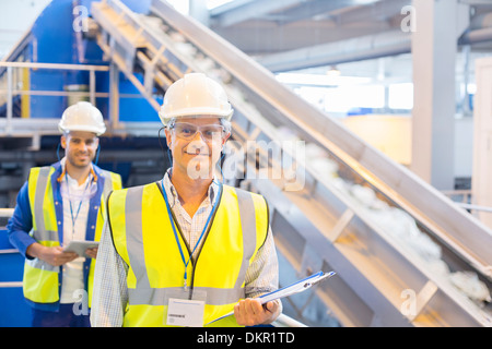 Workers smiling in recycling center Banque D'Images