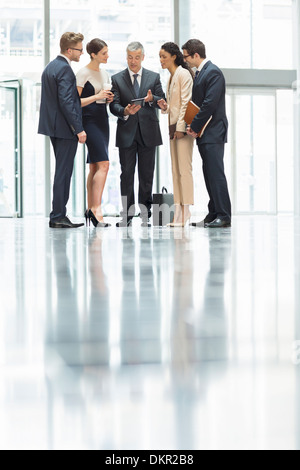 Business people talking in office lobby Banque D'Images