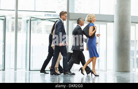 Business people walking in office lobby Banque D'Images