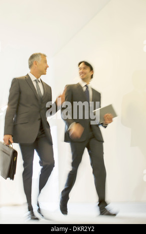 Businessmen talking in office corridor Banque D'Images