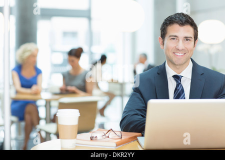 Businessman using laptop in cafe Banque D'Images