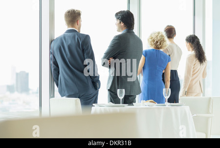 Les gens d'affaires looking out window in restaurant Banque D'Images