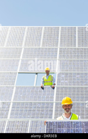 Worker holding solar panel in rural landscape Banque D'Images