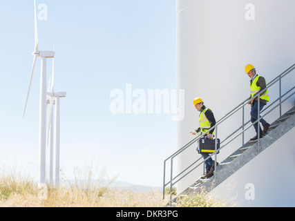 Les travailleurs sur wind turbine in rural landscape Banque D'Images