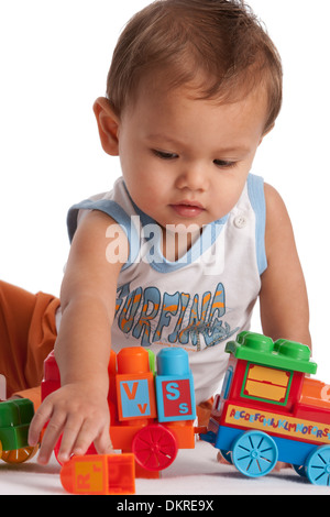 Bébé Garçon jouant avec les jouets sur fond blanc Banque D'Images