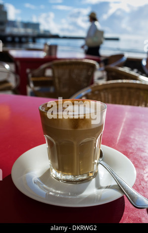 Cafe con leche dans un verre à une terrasse extérieure cafe à El Medano, Tenerife, Canaries, Espagne. Banque D'Images