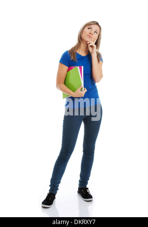 Young casual female student with cahier est pensée. Isolé sur blanc. Banque D'Images