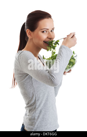 Young casual woman eating la mâche. Isolé sur blanc. Banque D'Images