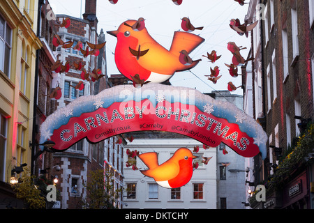 L 'année de la Robin' décorations de Noël accrocher au-dessus de Carnaby Street, Londres, Angleterre Banque D'Images