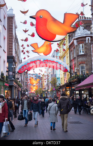 L 'année de la Robin' décorations de Noël suspendu au-dessus de Carnaby Street, Londres, Angleterre, en tant que personnes boutique de cadeaux Banque D'Images