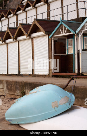 Bateaux renversés sur la plage en face de cabanes de plage à Swanage en Décembre Banque D'Images