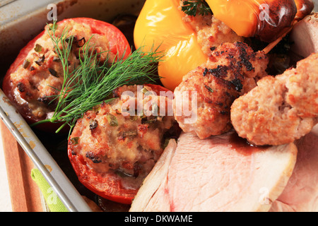 Rôti de porc, brochettes de viande hachée et les tomates et poivrons farcis dans un plat allant au four Banque D'Images