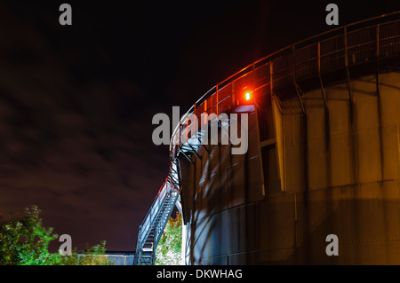 Un gazomètre de nuit, utilisé dans le stockage et la régulation de la pression du gaz local Banque D'Images