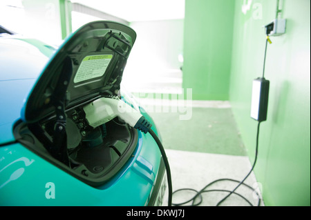 Une Nissan Leaf Voiture électrique d'être facturés à un parc de voiture à Annecy, France, Europe. Banque D'Images