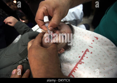 Gaza, Territoires Palestiniens, . 9Th Mar, 2013. Un agent de santé palestinien administre le vaccin contre la poliomyélite chute à un enfant pendant cinq jours d'une campagne anti-polio, à Gaza le 09 décembre 2013. Le ministre de la santé dans la bande de Gaza, Mufid al-Mokhalalaty, a dit dimanche que son ministère commenceront une campagne anti-polio de vacciner 300 000 enfants en ligne avec le plan de l'Organisation mondiale de la santé d'arrêter une épidémie de polio en l'an 2015.Photo : Moemen Faiz/NurPhoto NurPhoto © Moemen Faiz/ZUMAPRESS.com/Alamy/Live News Banque D'Images