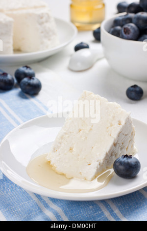 Close up de fromage blanc avec du miel et bleuets frais Banque D'Images
