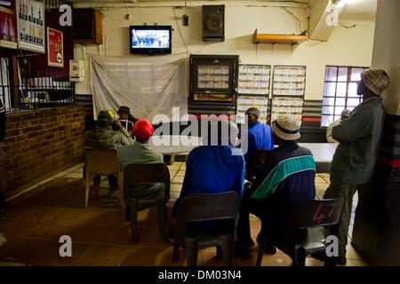 Johannesburg, Afrique du Sud. Dec 10, 2013. Les gens qui regardent le service commémoratif sur leur accueil télévision à Onverwacht, le 10 décembre 2013, à Pretoria, Afrique du Sud. Le père de la Nation est décédé paisiblement le soir du 5 décembre 2013 à son domicile à Houghton en famille. Il sera enterré à Qunu pour les funérailles d'État le 15 décembre 2013. Credit : Gallo images/Alamy Live News Banque D'Images
