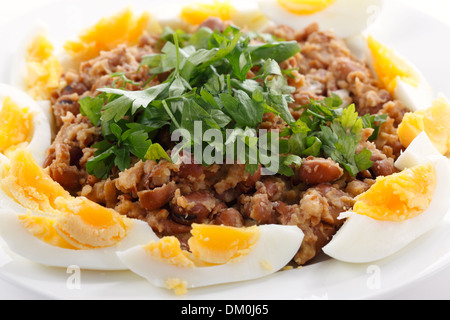 Foul égyptien ou - ful - garneshed Foul Medemes sur une assiette avec des tranches d'œuf dur et de persil plat. Banque D'Images