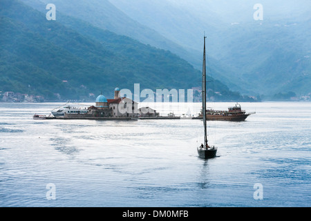 Baie de Kotor. Petite île Notre Dame des roches et yacht à voile Banque D'Images