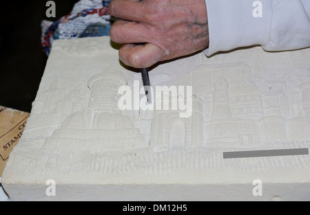 Sculpteur travaille sur un bas-relief en pierre Banque D'Images