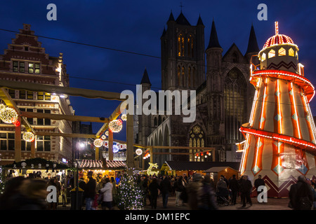 Helter Skelter illuminé et gens du shopping au marché de Noël en soirée en hiver, Korenmarkt / Marché du maïs, Gand, Belgique Banque D'Images