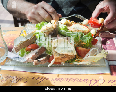 L'homme de manger de la salade au fromage de chèvre régional et pate ,close up, restaurant à Thones Haute-Savoie France Banque D'Images