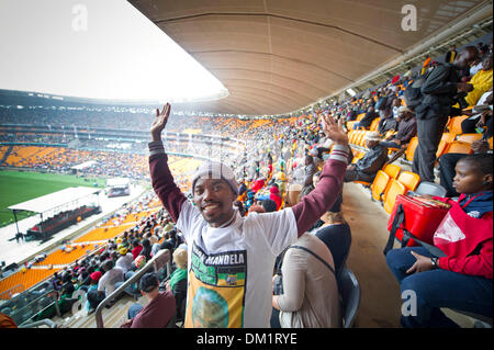 Johannesburg, Afrique du Sud. 10 décembre 2013. Des milliers de personnes se sont réunis pour rendre un dernier hommage à feu l'ancien Président sud-africain, Nelson Mandela, au cours du service commémoratif tenu à la FNB stadium de Soweto, près de Johannesburg. Personnes chanter dans la pluie pendant la célébration. Photo par ImageSA/Alamy Live News Banque D'Images