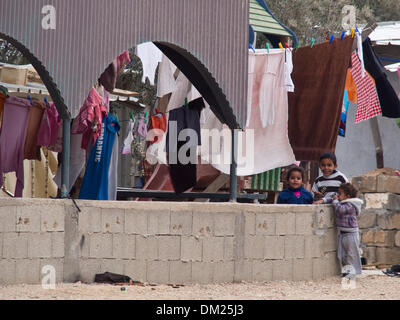 Nord du Néguev, en Israël. Dec 10, 2013. Les enfants bédouins stand à l'entrée de leur maison dans le village d'Bir-Mashash non reconnus. Ce village est prévu d'être légalisé si des accords peuvent être conclus avec ses résidents. Nord du Néguev, en Israël. 10-Dec-2013. Le Bureau du Premier ministre pousse en avant le projet de loi pour l'Arrangement de règlement des Bédouins du Néguev à la suite d'une première lecture à la Knesset et malgré une large controverse et de violentes manifestations au cours des dernières semaines. Credit : Alon Nir/Alamy Live News Banque D'Images