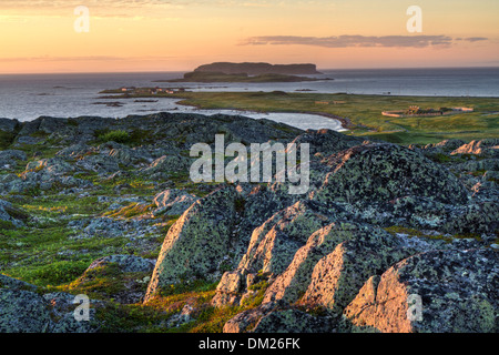 Coucher de soleil depuis une colline rocheuse surplombant une colonie viking à L'Anse Aux Meadows Lieu historique national dans le nord de Terre-Neuve Banque D'Images