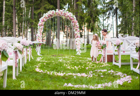 Bancs de mariage avec les invités et de l'extérieur de la cérémonie de passage de fleurs Banque D'Images